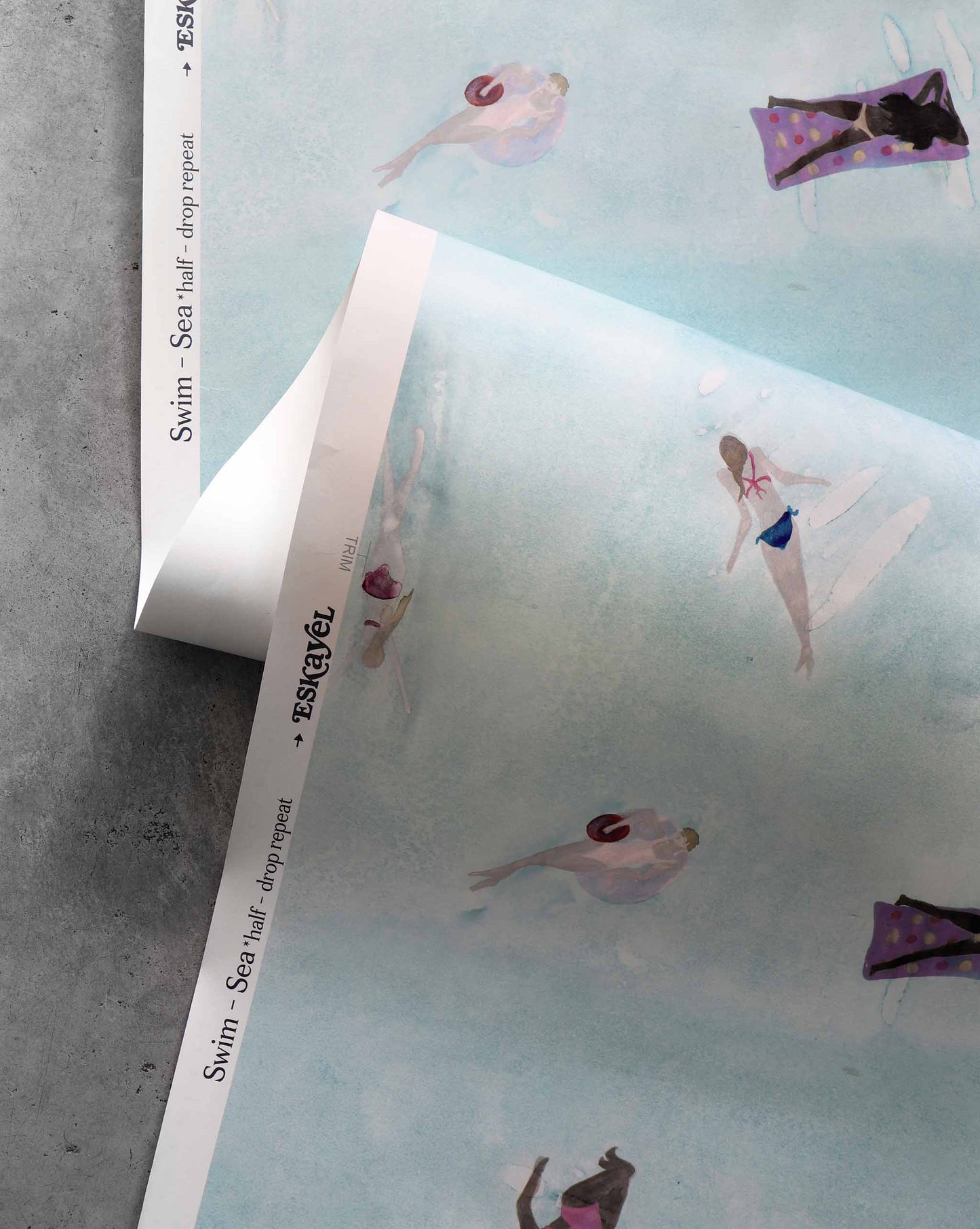 A closeup image of Swim Sea wallpaper with its light blue background and waterborne female figures throughout.