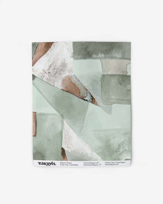 Our Pieces Wallpaper in Tourmaline has a design of colorblocked puzzle pieces in shades of green and a brown color throughout.