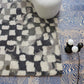 A Chess Hand Knotted Rug 5' x 8' in Greyscale with a blue and white Moroccan weave pattern on it