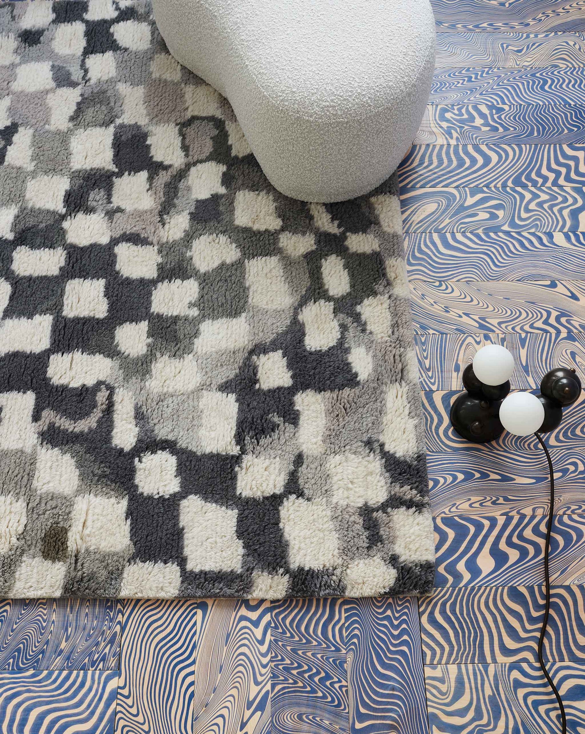 A Chess Hand Knotted Rug 5' x 8' in Greyscale with a blue and white Moroccan weave pattern on it
