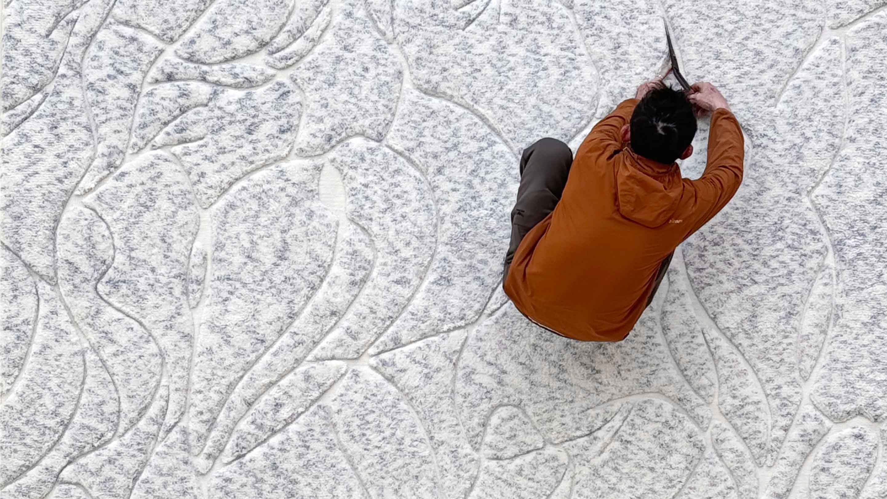 Eskayels hibiscus lily rug being trimmed by worker.
