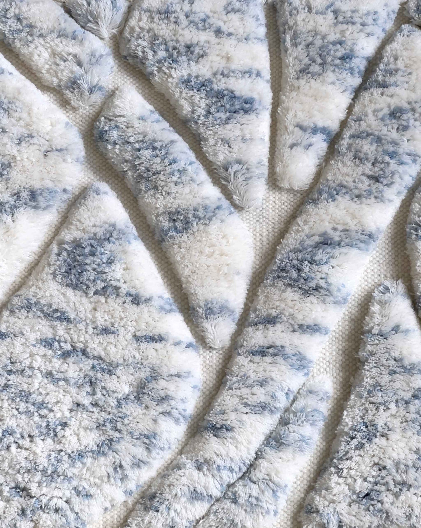 A swatch of Eskayel’s Hibiscus Lily rug in Sky shows a colorway of white and blue shades.