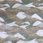 A sumptuous merino wool Mani Hand Knotted Rug 5' x8' Earth with a camouflage pattern and hand-cut bevels on the fabric