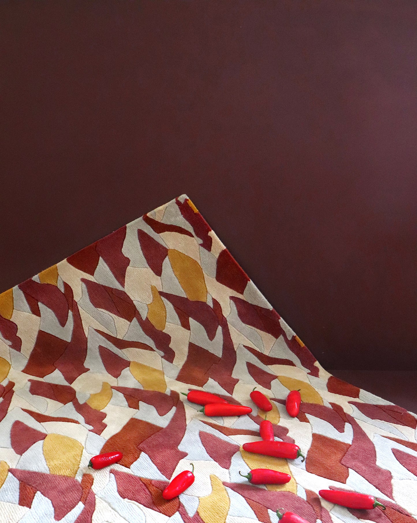 A sumptuous Mani Hand Knotted Rug Fire with red peppers on it