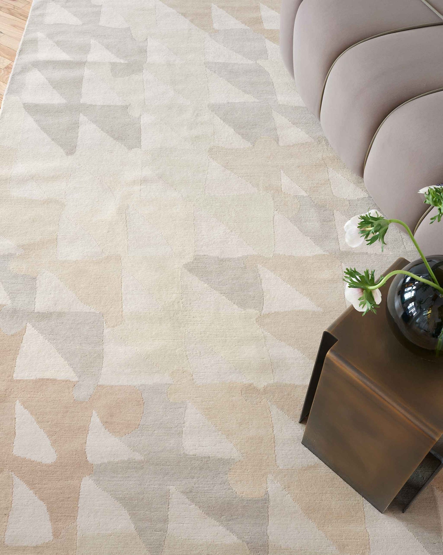 A living room with a beige Triangle Checks Hand Knotted Rug Sol