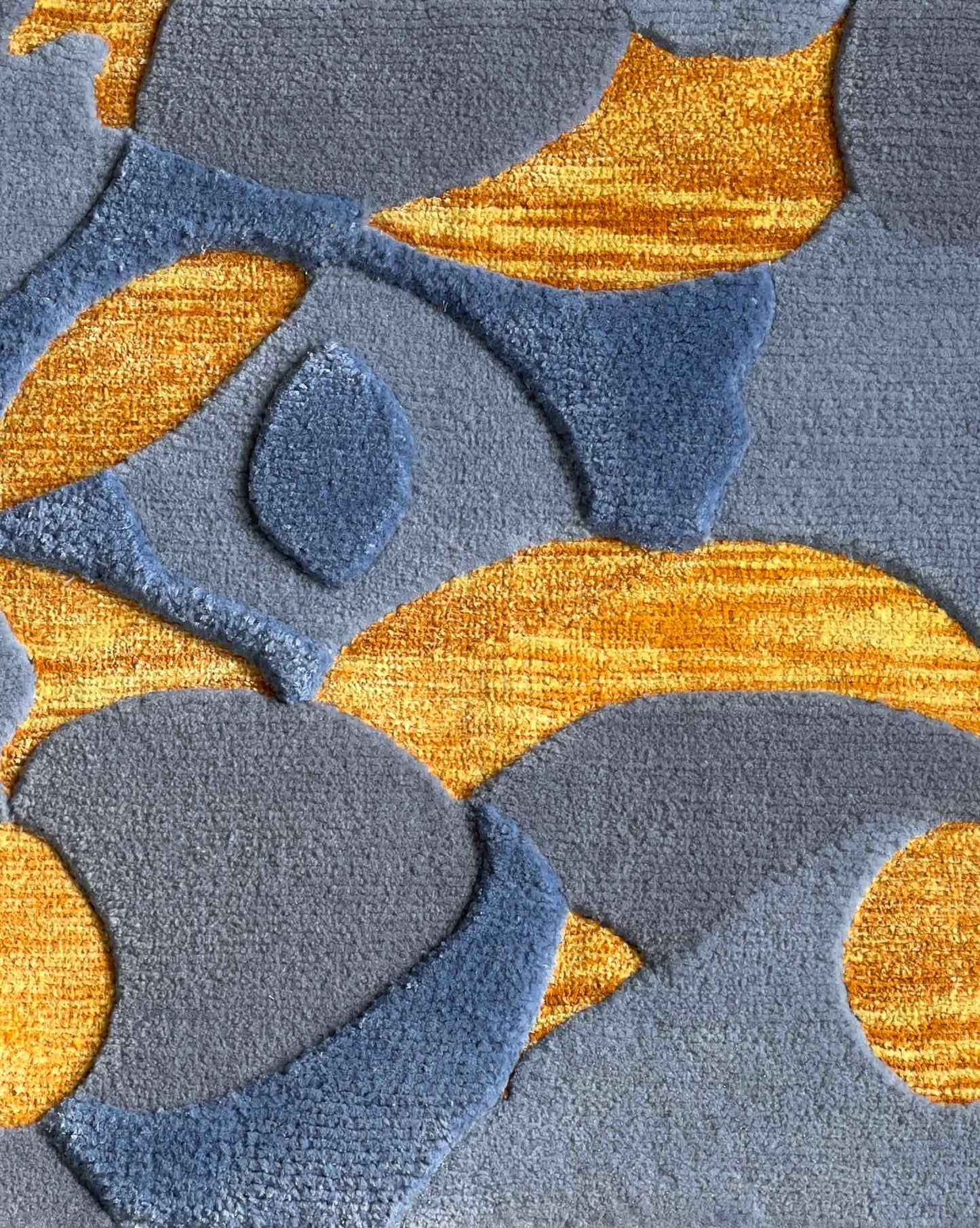 A swatch of Eskayel’s Orbs rug in the Sky and Sun colorway depicts blue, yellow, and orange in wool and silk fibers.