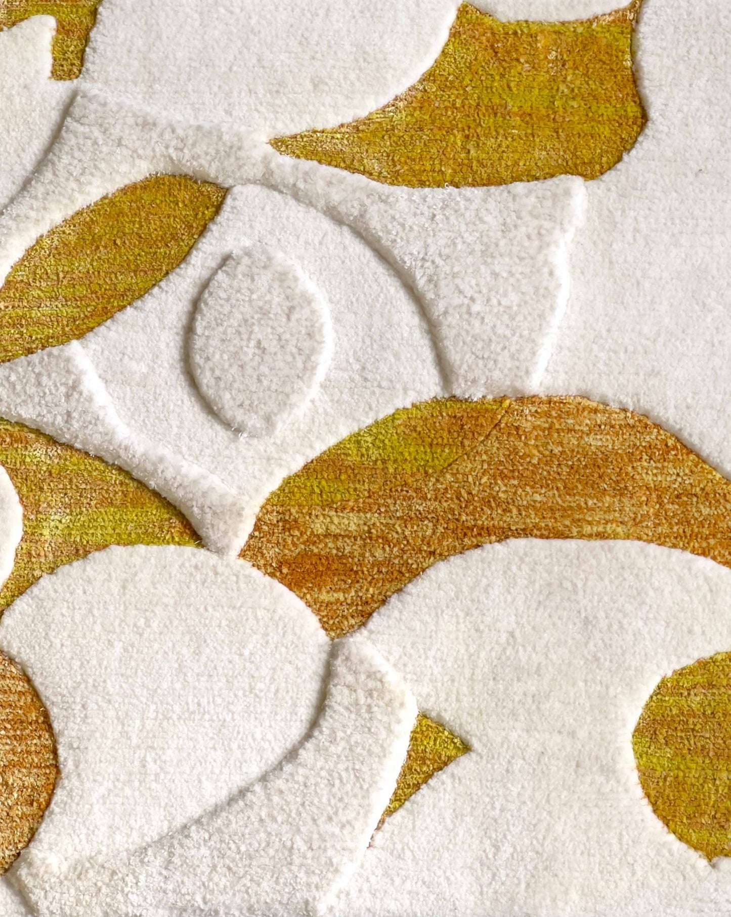 A closeup of Eskayel’s Orbs rug in the Sun colorway displays wool and silk pile in white, yellow, and orange.