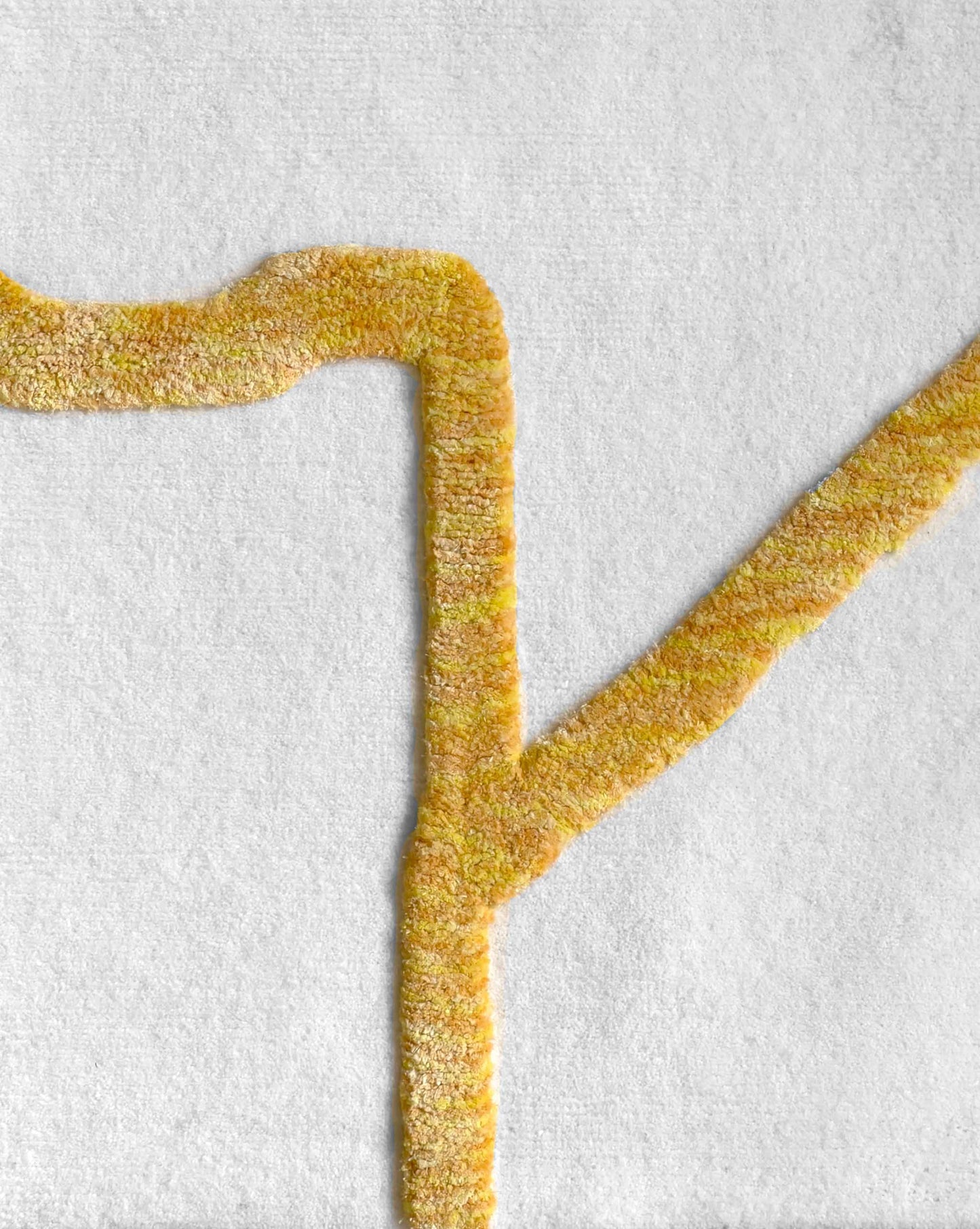 In this swatch of the Pieces rug from Eskayel, the Sun colorway is a palette of a white, yellow, and orange.
