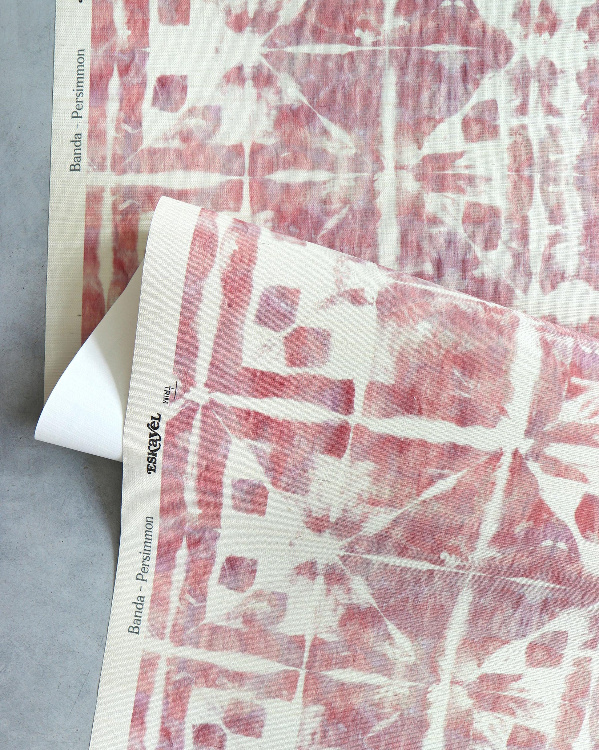 A piece of wallpaper with a Banda Grasscloth Persimmon pattern using shibori tie-dye techniques