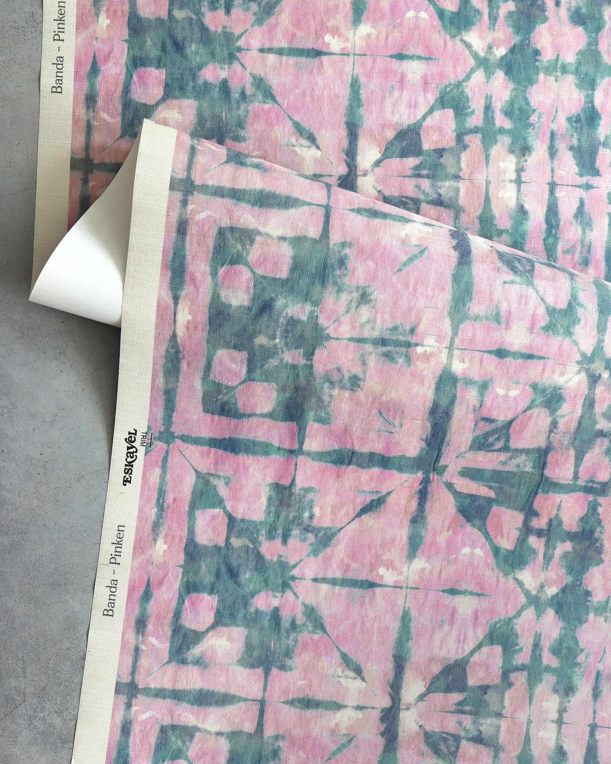 A Banda Grasscloth Pinken fabric by Eskayel on a table