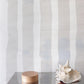 A glass table with a Bold Stripe Grasscloth Sand on it