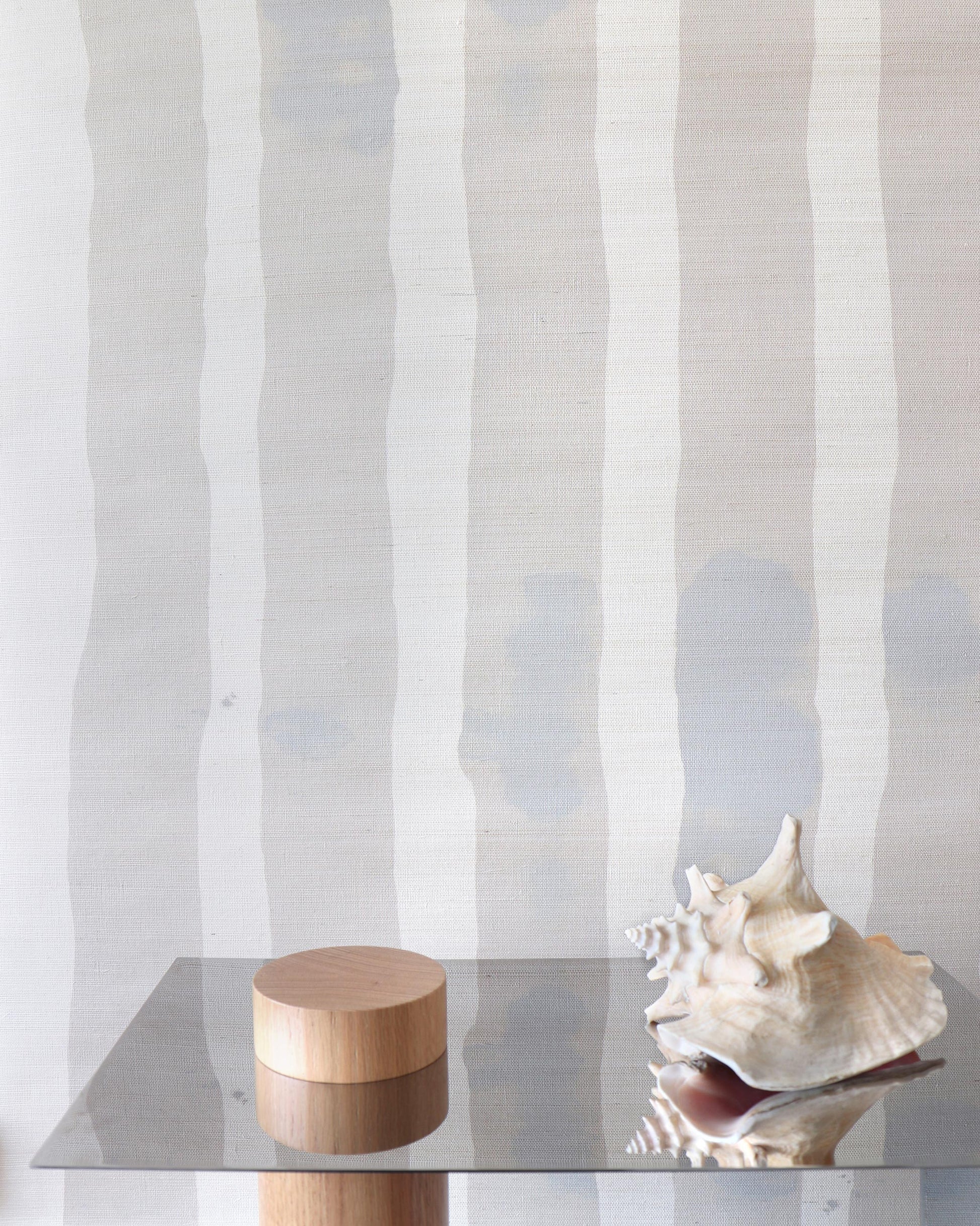 A glass table with a Bold Stripe Grasscloth Sand on it