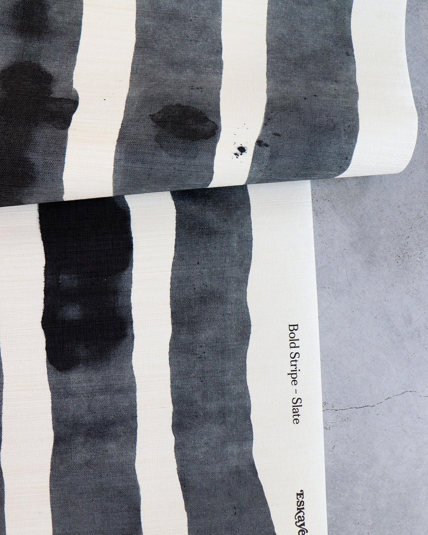 A black and white striped Bold Stripe Grasscloth Slate on a table from Eskayel's Stripes Collection