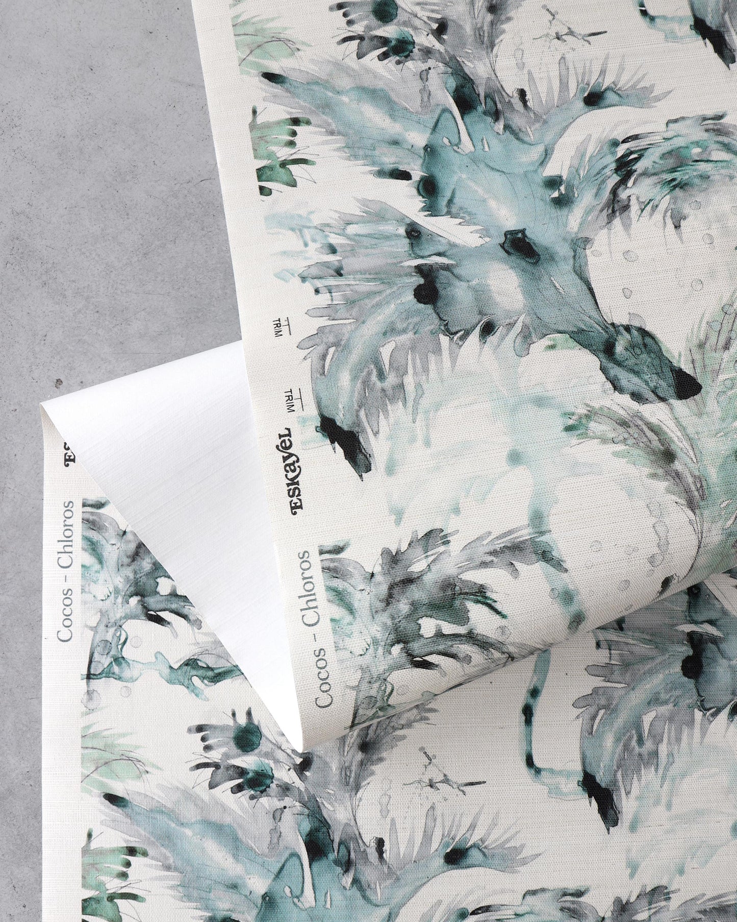 A folded piece of paper with the Cocos Grasscloth Chloros luxury blue and green floral pattern