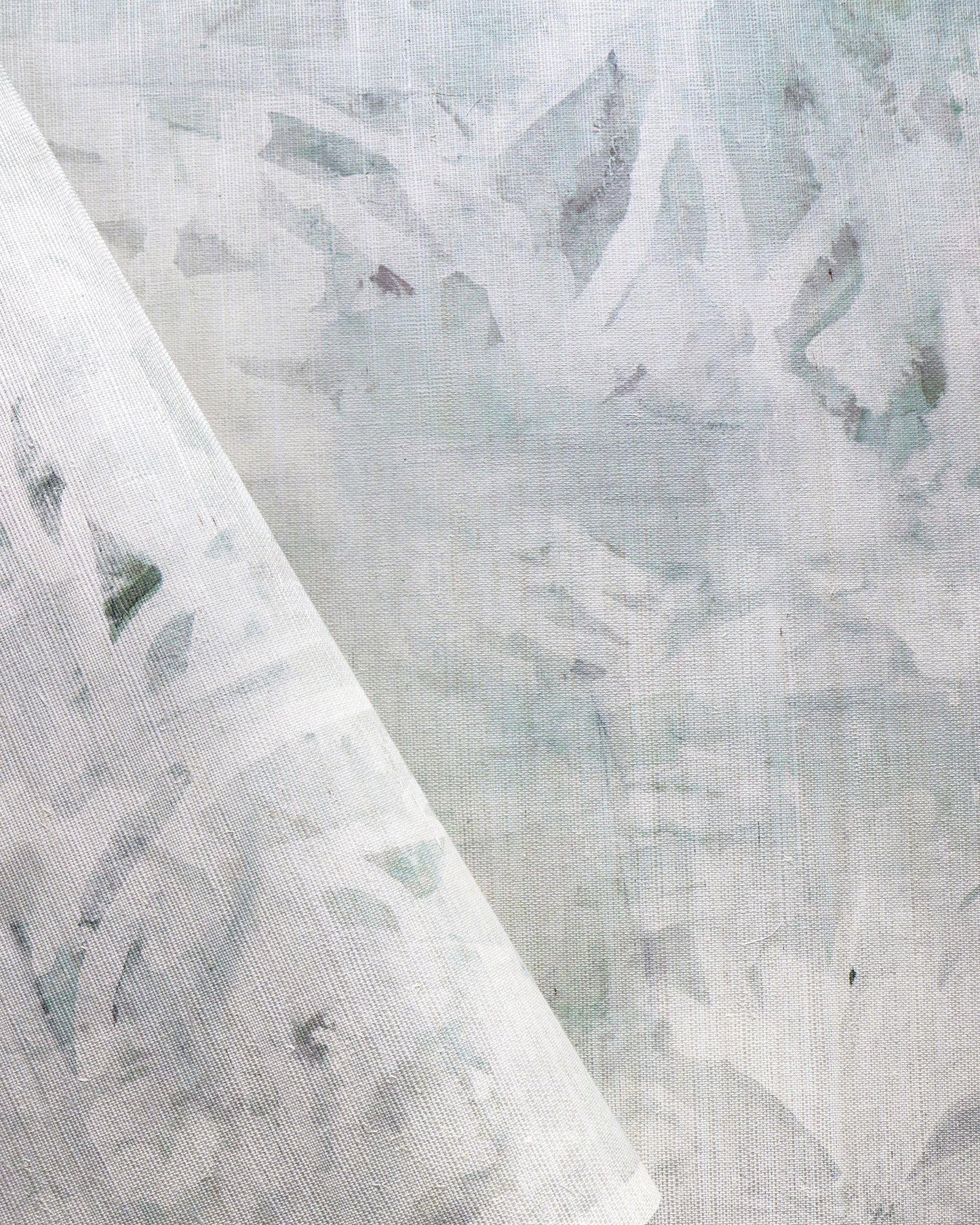 A close up of a piece of custom grasscloth wallpaper with the pattern "Cortile Grasscloth Alba" on it