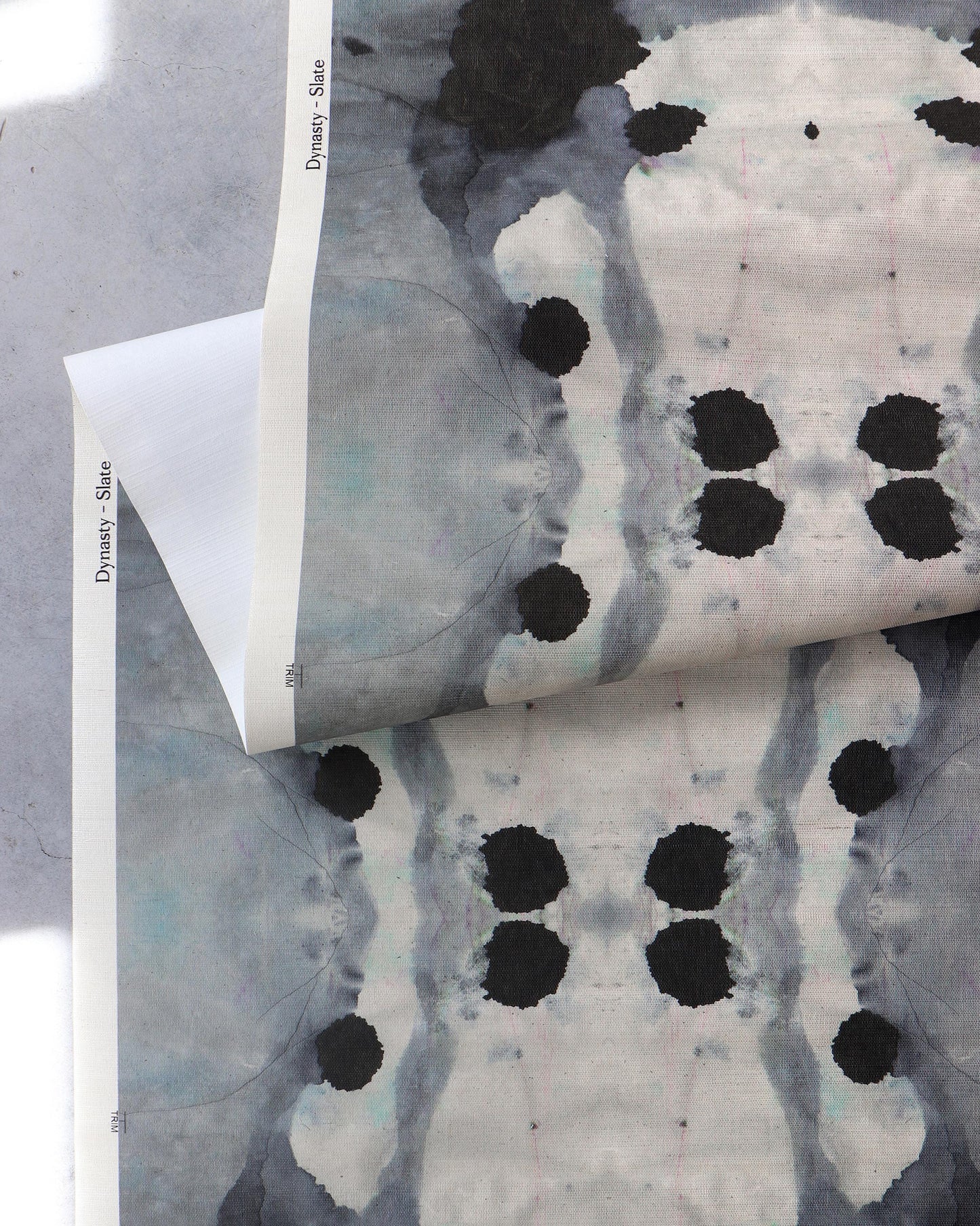 A piece of Dynasty Grasscloth Slate with ink blot design on it