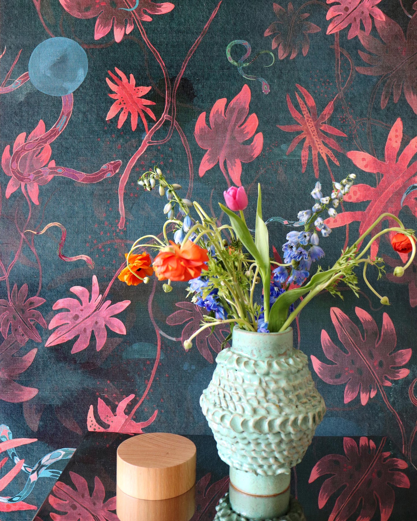 A vase filled with Edera Grasscloth Beryl flowers on a table