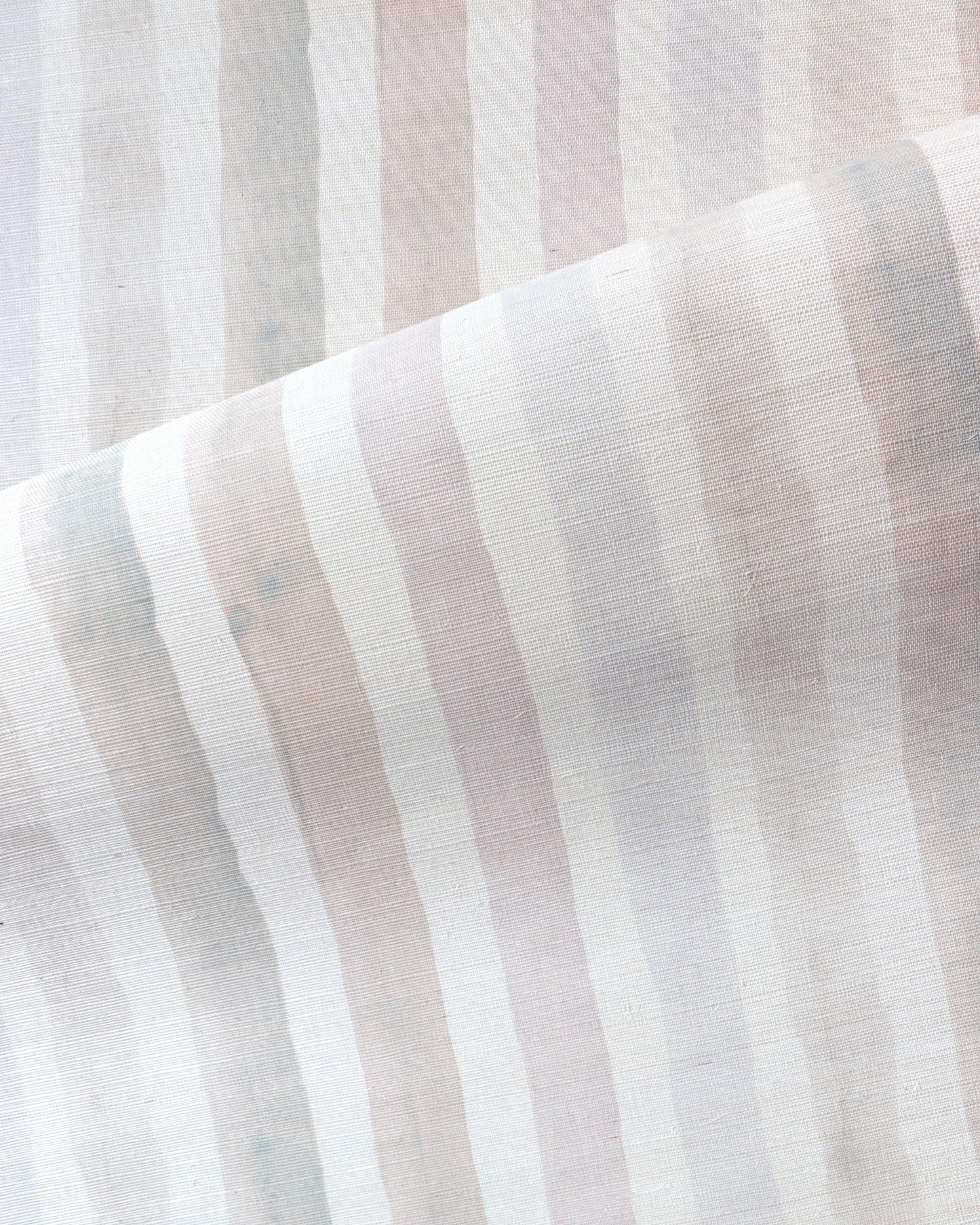 A close up image of a Gradient Stripe Grasscloth Pink Island fabric in gradient stripe colorways