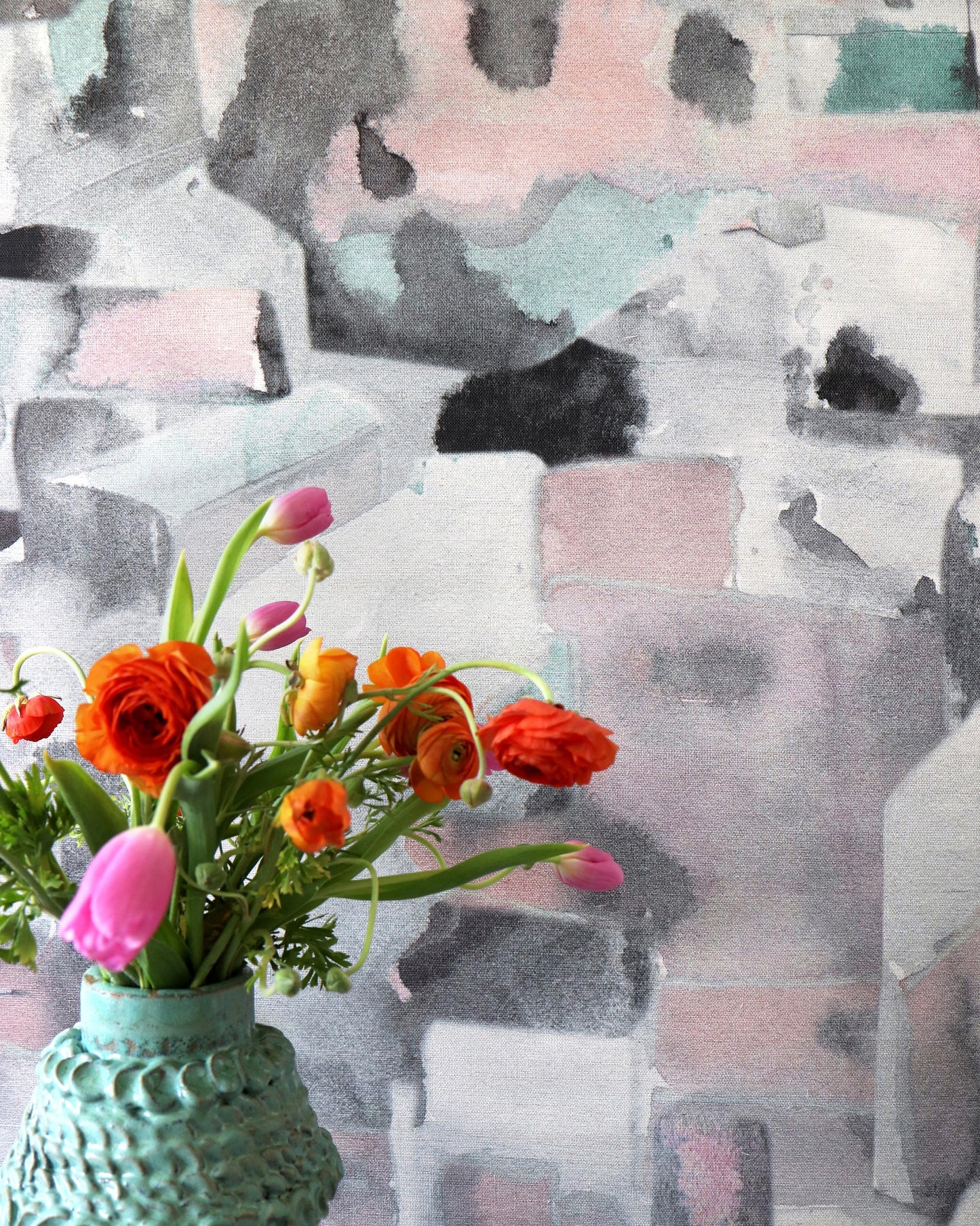 A vase of Medina Grasscloth Duomo on a table in front of a painting in Marrakesh roads