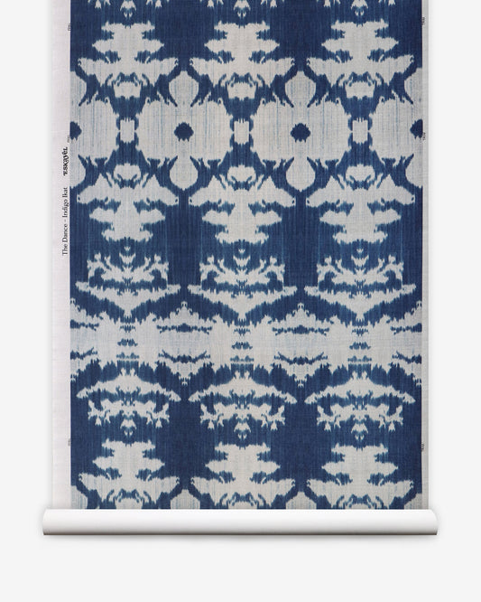 A blue and white The Dance Grasscloth Indigo ikat pattern on a roll of grasscloth wallcovering