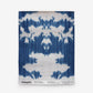 A blue and white ikat pattern on wallpaper is part of The Dance Grasscloth Indigo ikat Collectionon wallpaper