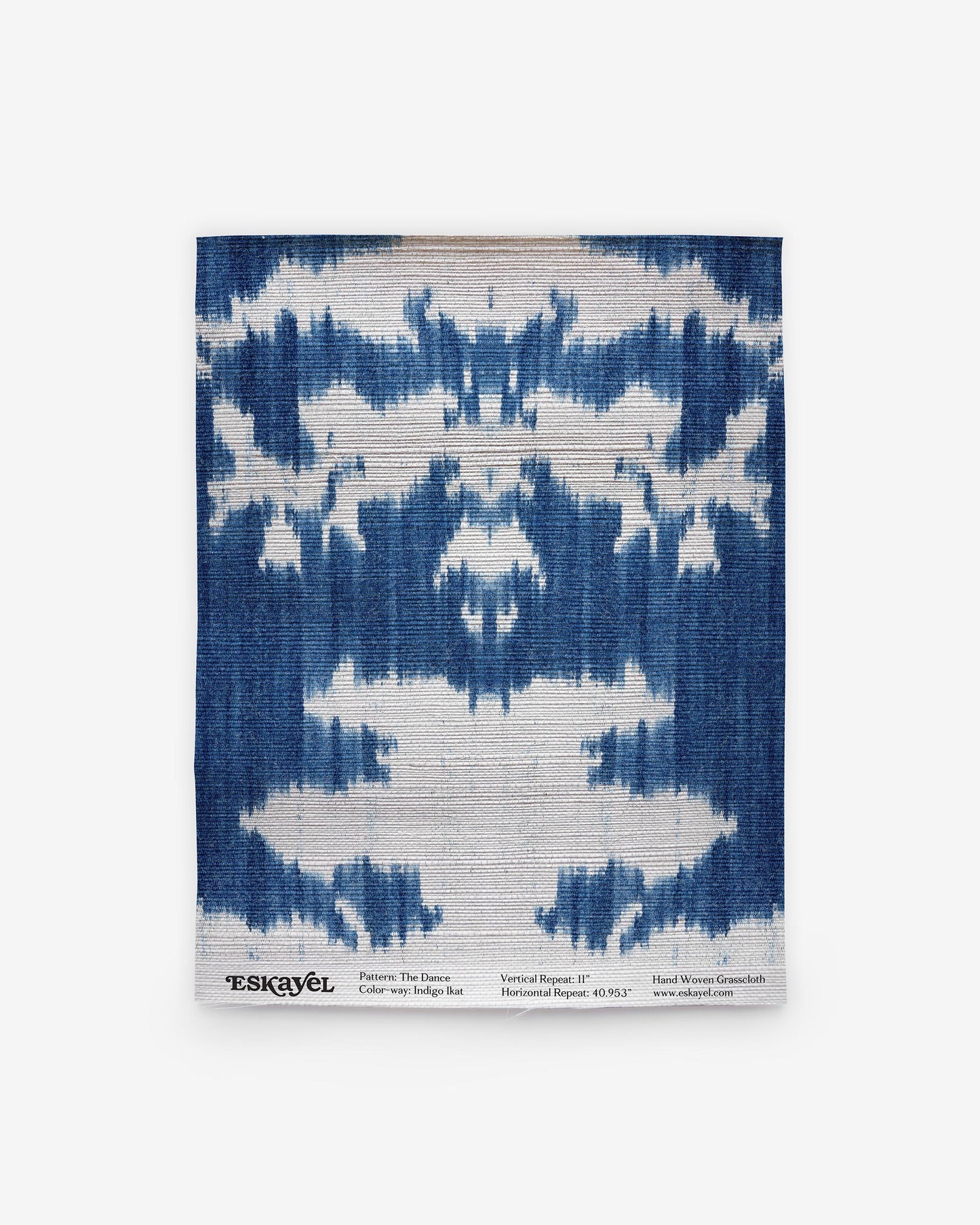 A blue and white ikat pattern on wallpaper is part of The Dance Grasscloth Indigo ikat Collectionon wallpaper