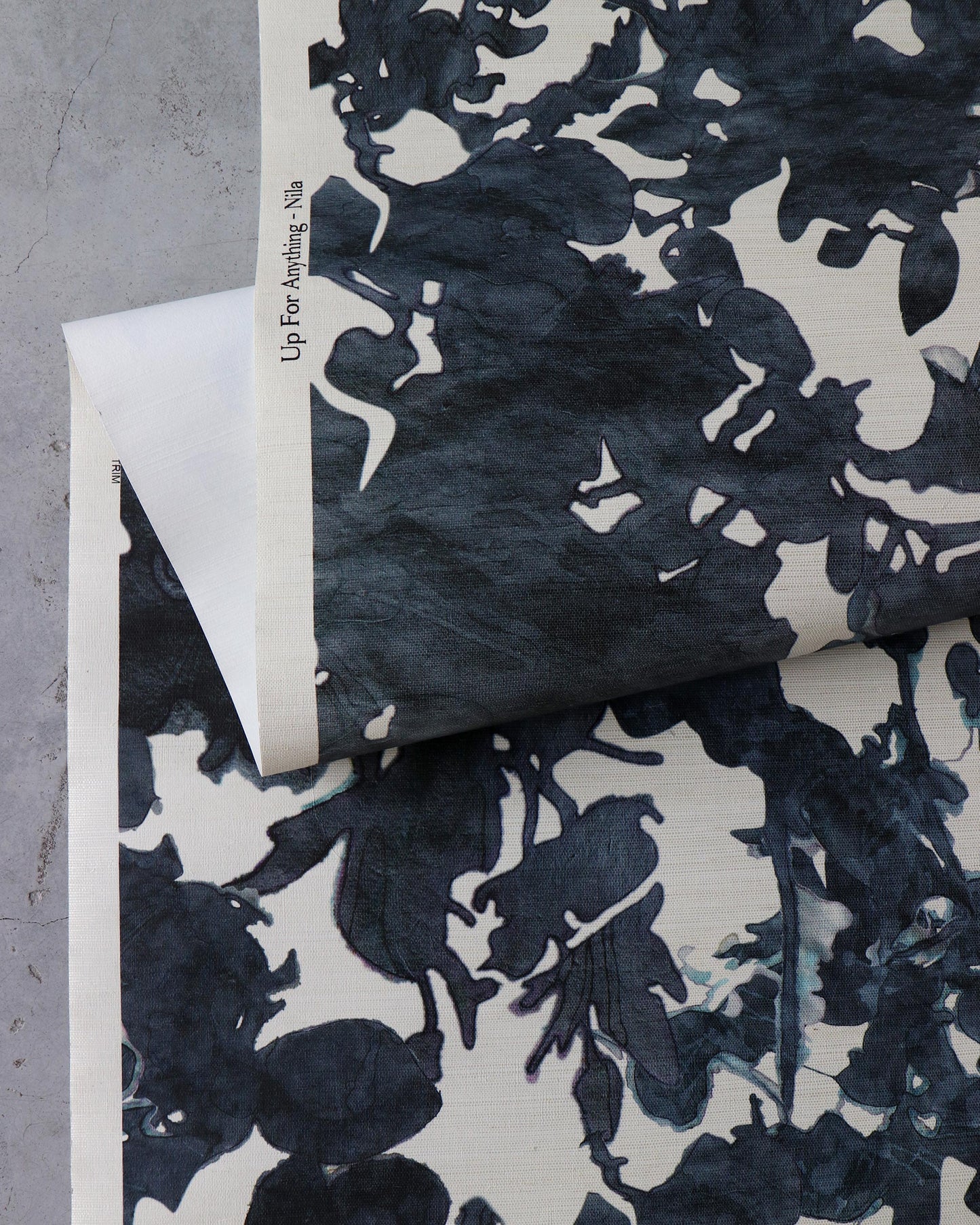 A monochrome Up for Anything Grasscloth Nila print on a piece of wallpaper
