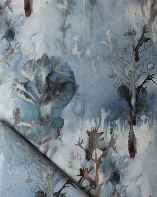 A close up of a blue Aionas fabric with trees on it The fabric showcases intricate patterns of trees, creating a mesmerizing display reminiscent of Aionas