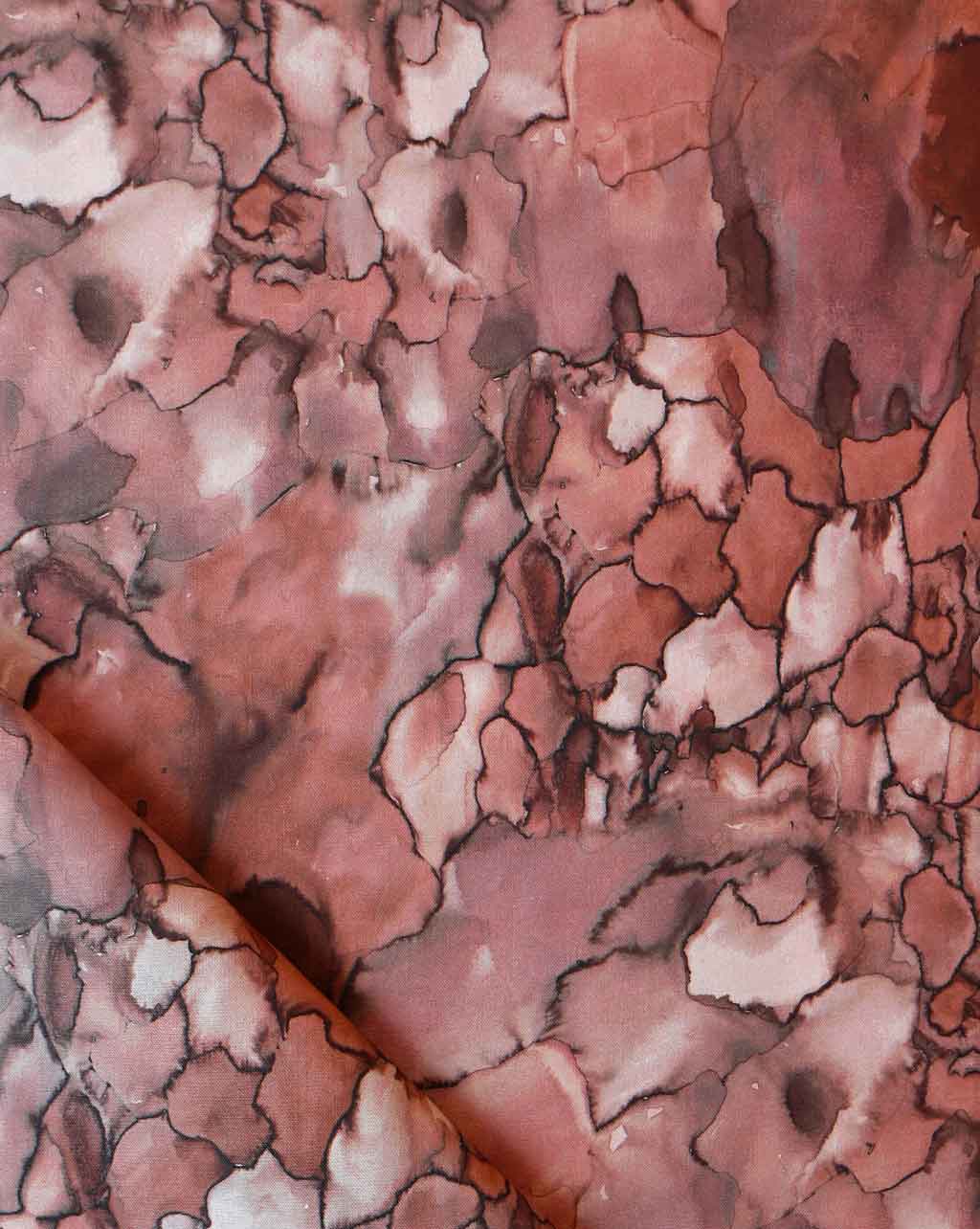 A close up of the Aquarelle Fabric in Earth colorway, showcasing nature's raw power in the pink and brown marbled pattern