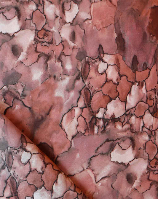 A close up of the Aquarelle Fabric in Earth colorway, showcasing nature's raw power in the pink and brown marbled pattern