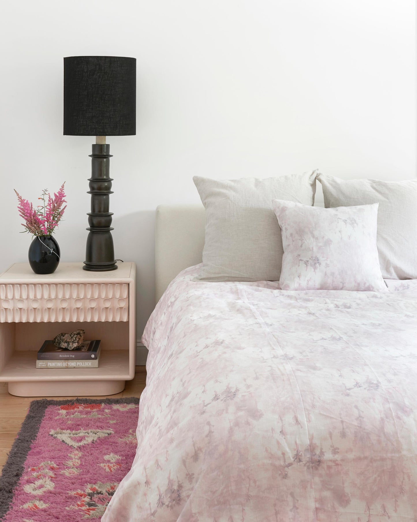A bedroom with a pink bed and pink pillows made of Emvasia Fabric Alba