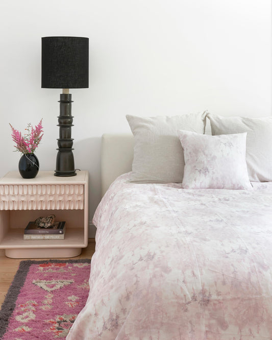A bedroom with a pink bed and pink pillows made of Emvasia Fabric Alba