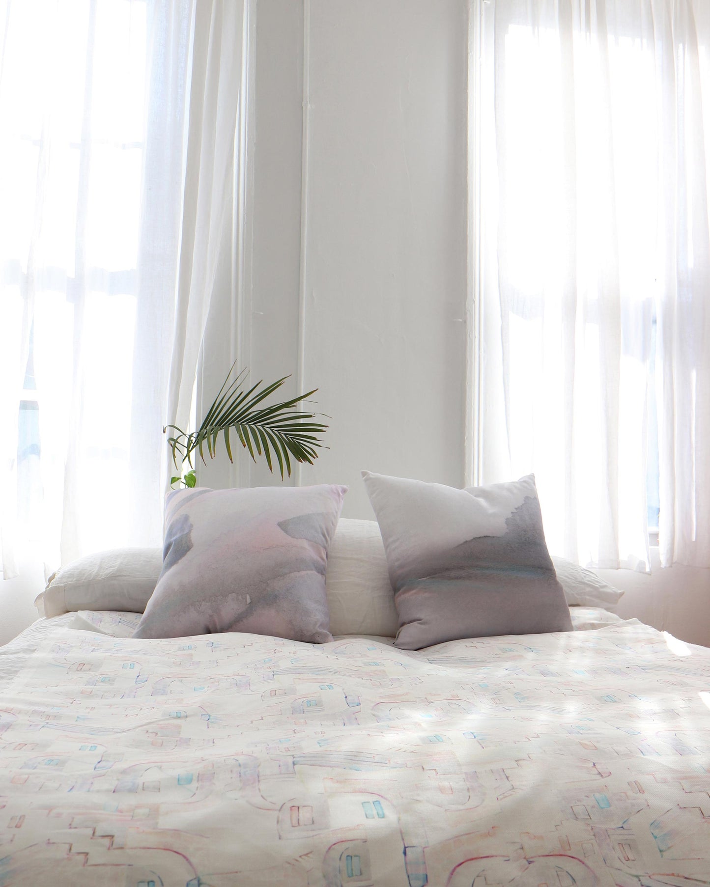 A bed with two pillows and a La Scala Fabric Multi on it