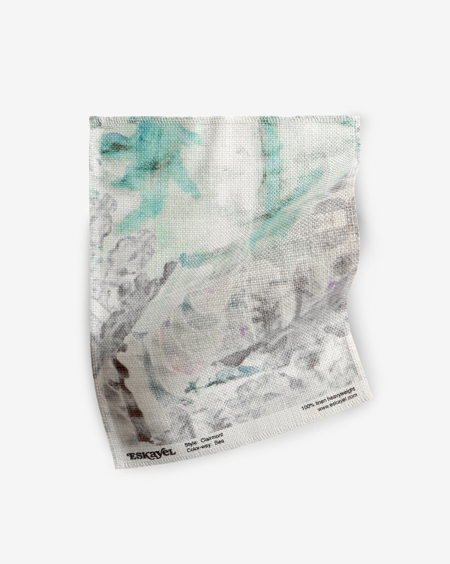 A white cloth with blue and green flowers on it can be transformed into Clairmont Fabric Sea or part of the Presidio Collection, becoming a luxury fabric