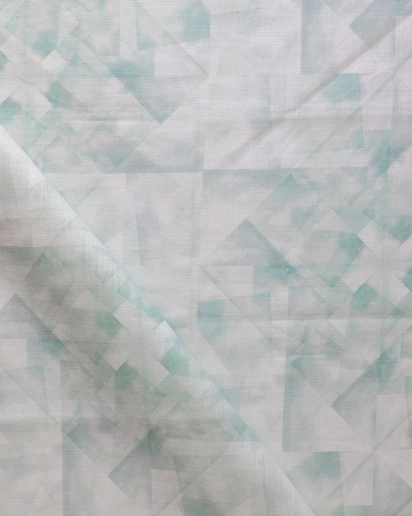A close up of a green and white Kalos Fabric Sage kaleidoscope style collage fabric