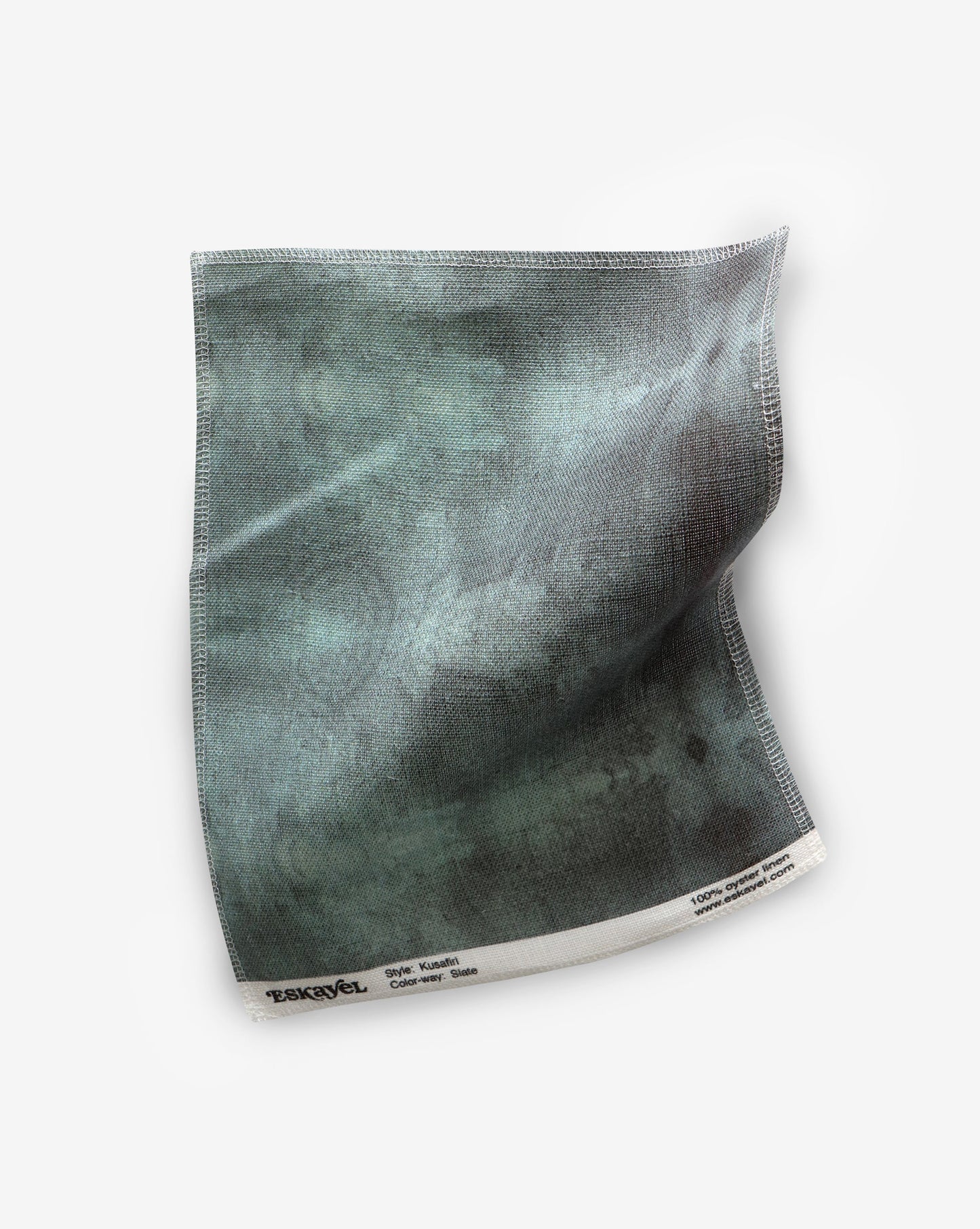 A green Kusafiri Fabric Slate fabric on a white surface in Tuscany