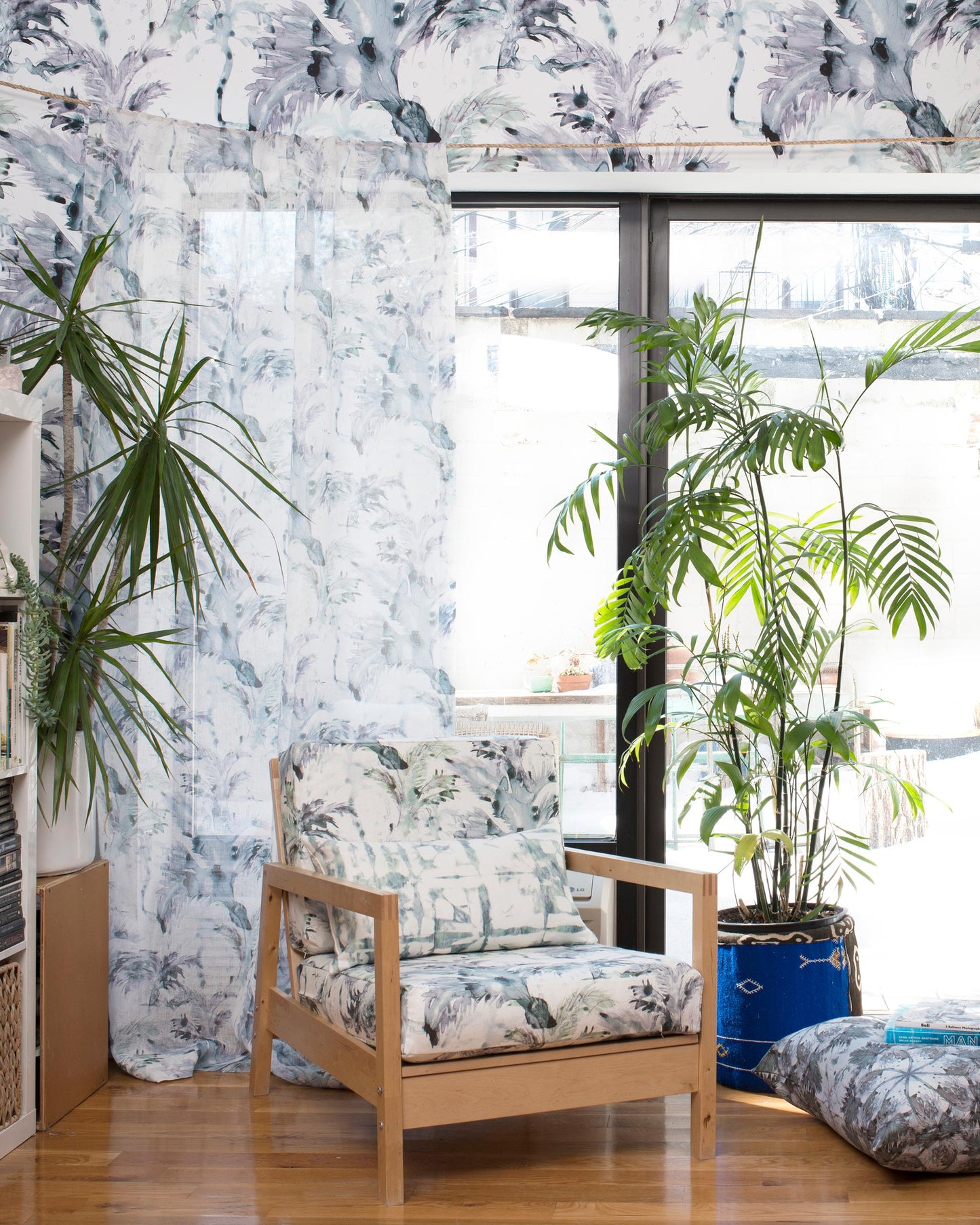 A chair in front of a window adorned with luxury Cocos Fabric Chloros motifs