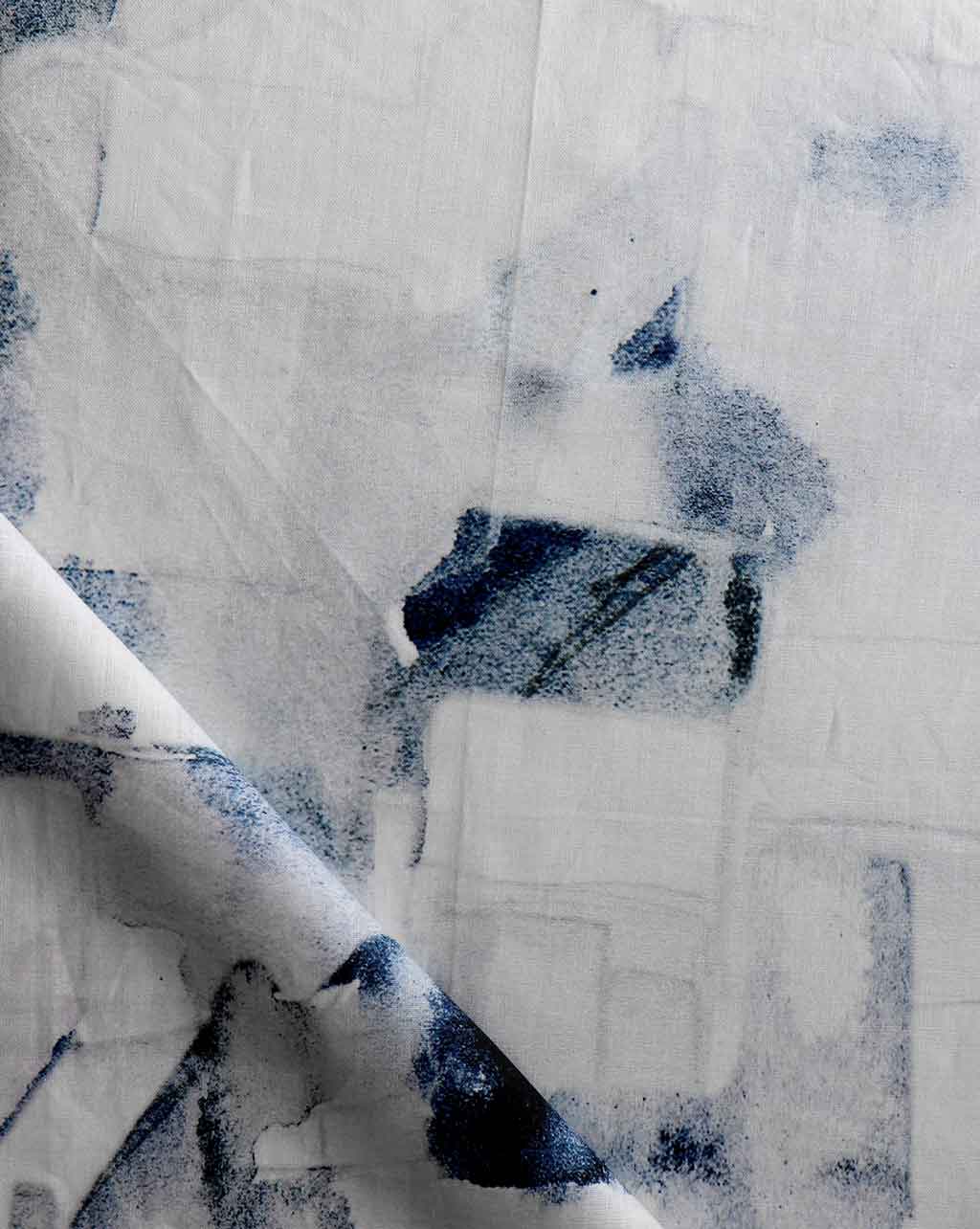 A close up of a blue and white Medina Fabric Cyrrus print on a piece of fabric in Medina