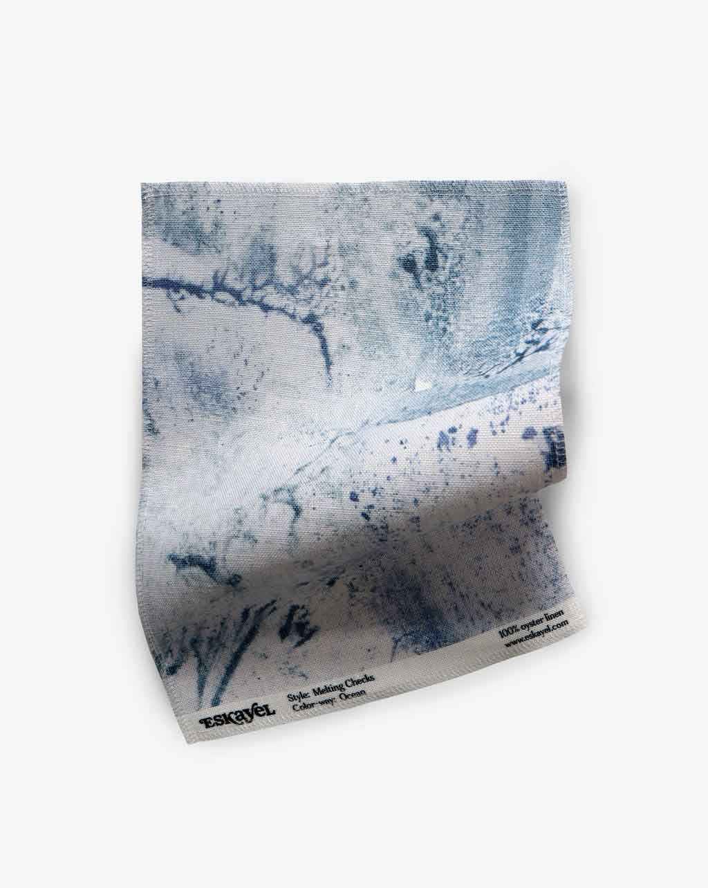 A piece of Melting Checks Fabric Ocean, featuring muted blues and a white pattern on it