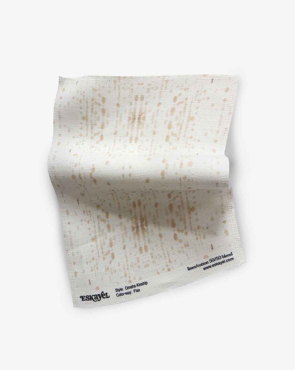 A piece of fabric with the Omaha Kinship Fabric Flax pattern is adorned on it