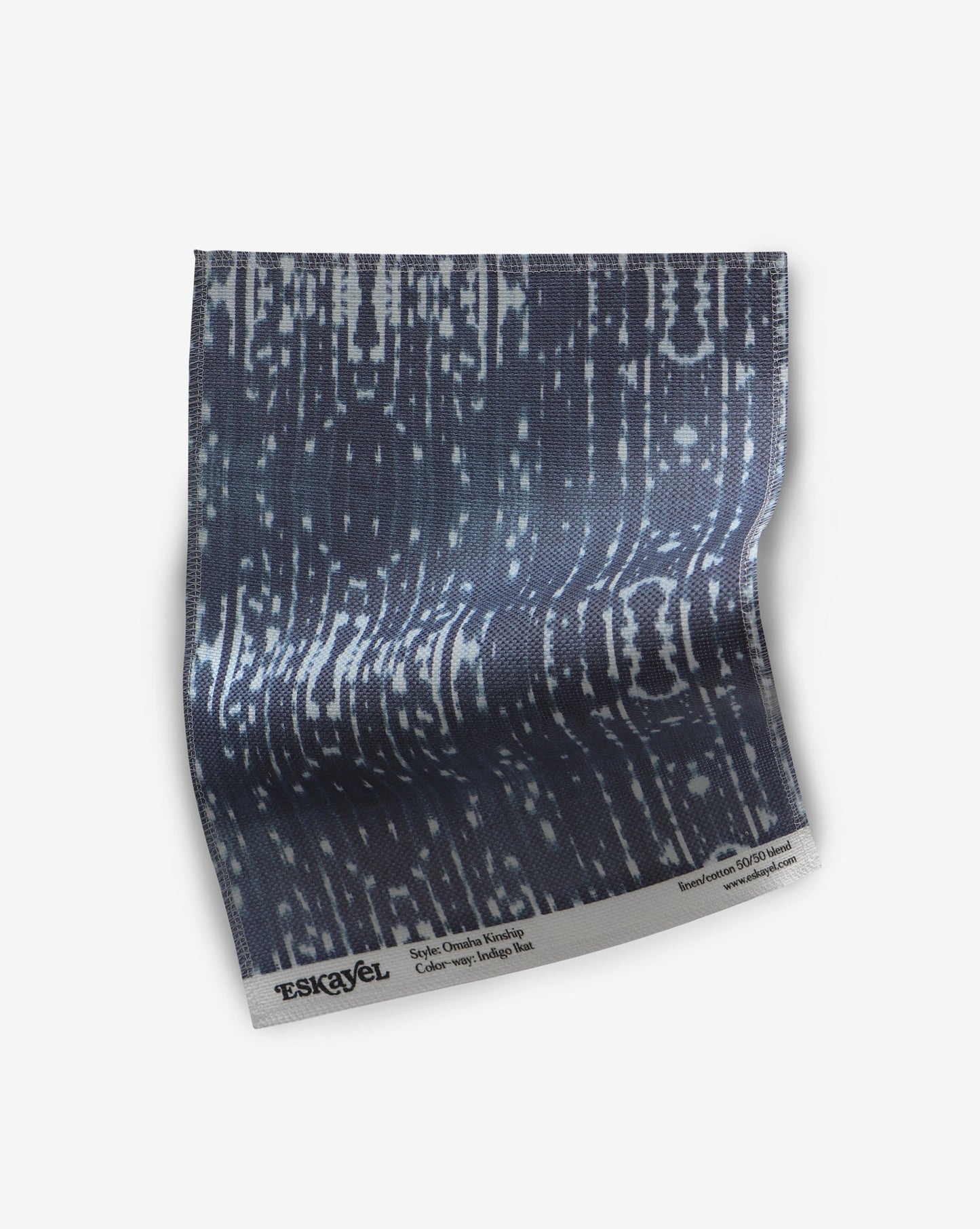 A piece of Omaha Kinship Fabric Indigo Ikat with a blue and white pattern on it