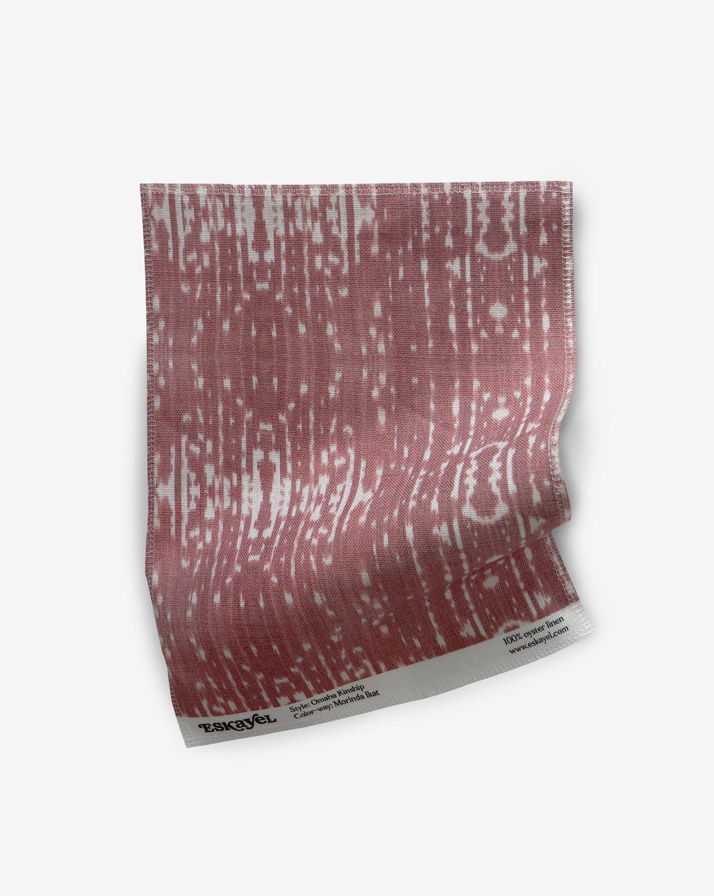 A pink and white pattern on a Omaha Kinship Fabric Sample Morinda Ikat piece of paper