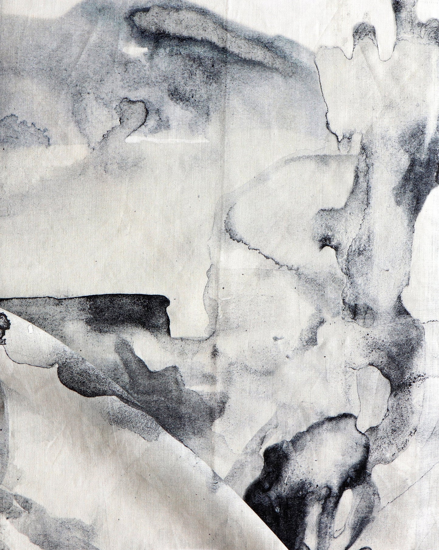 A piece of Palmeraie Fabric with black and white paint on it