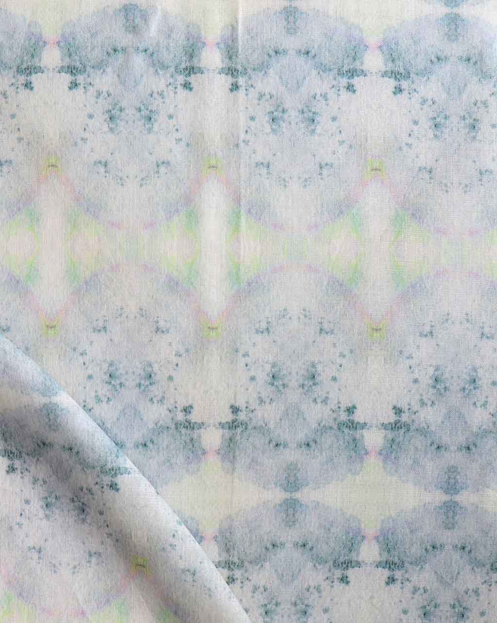 A close up of a white Parvati Fabric Nyanza with a Parvati pattern, featuring blue and green colors created using watercolor pigments