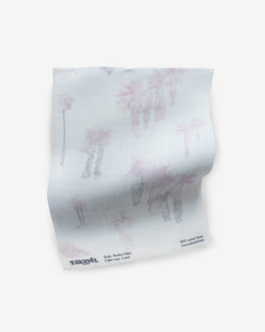 A white Perfect Palm Fabric Sample Coral fabric with pink palm trees on it