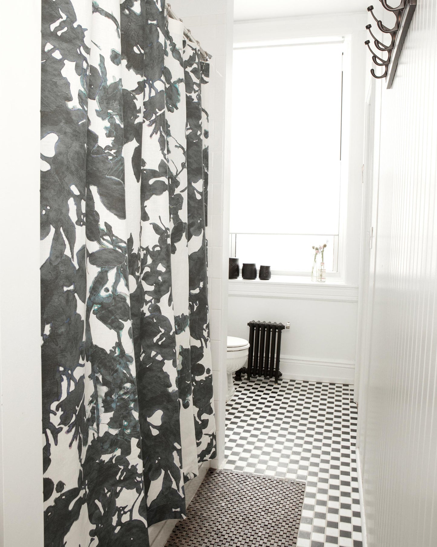 A black and white bathroom with a Up For Anything Fabric watercolor shower curtain