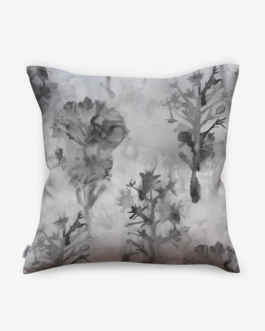 A pillow with an Aionas Pillow Phyllite image of trees and flowers