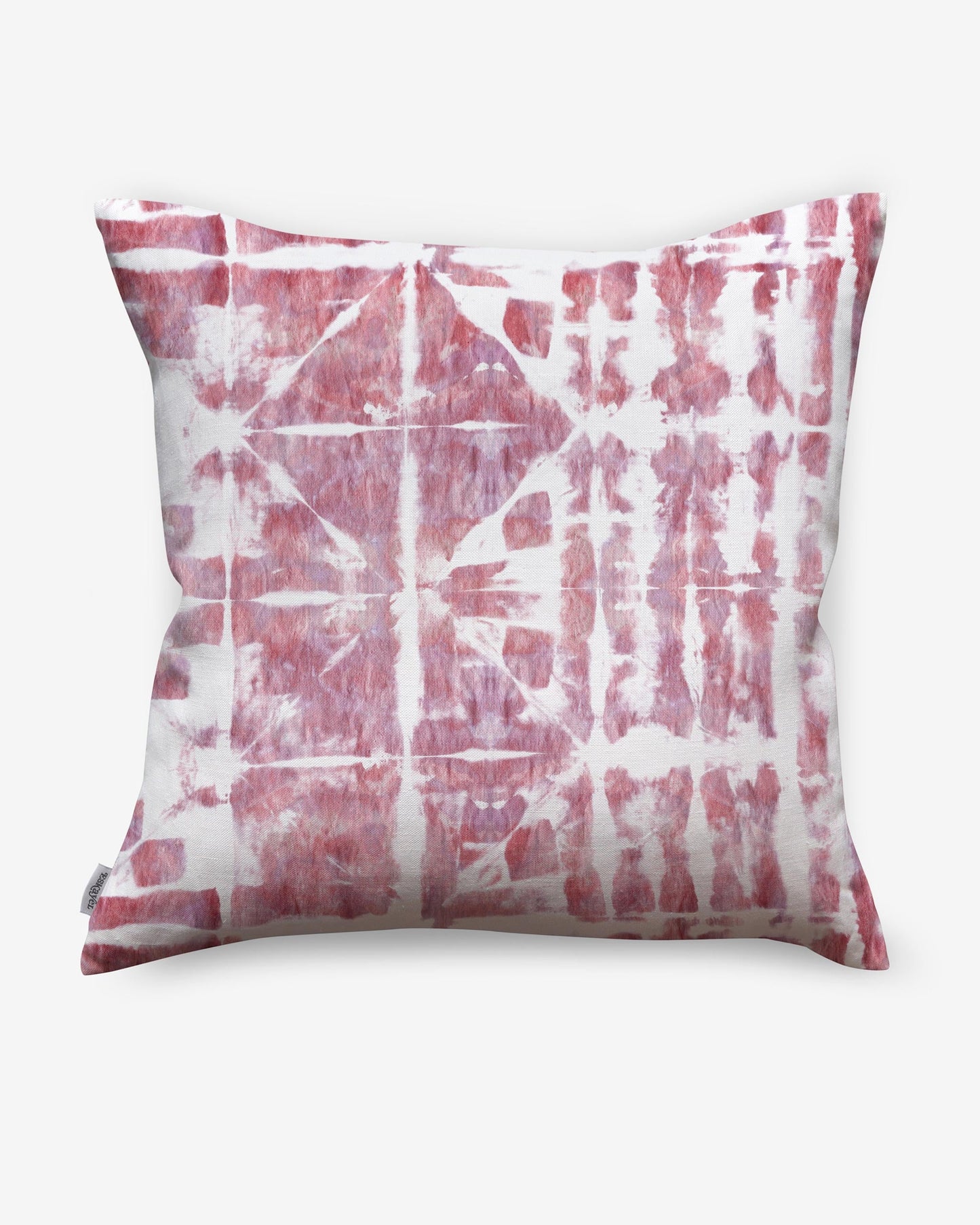 A pink and white Banda pillow with a tie dye pattern utilizing shibori tie-dye techniques