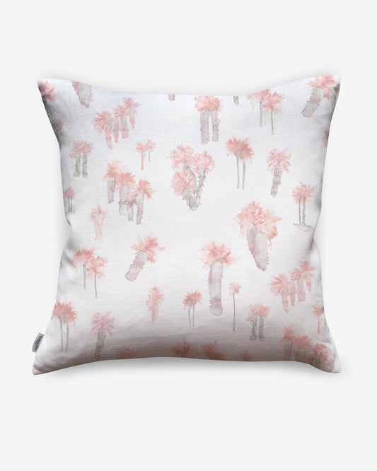A Perfect Palm Pillow Coral, a pink and white luxury feather pillow with a figurative pattern of palm trees on it