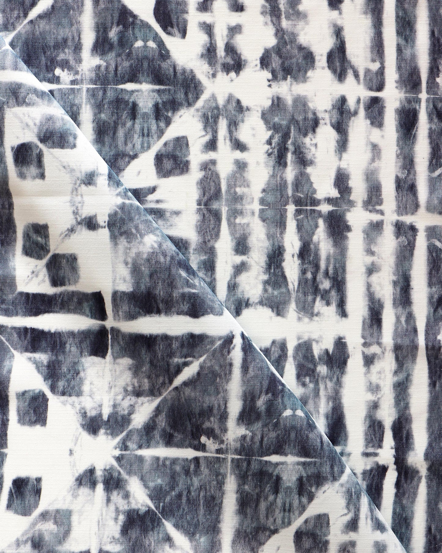 A close up of a blue and white tie dyed fabric, perfect for Banda Performance Fabric Midnight or luxury performance fabric